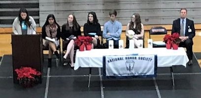 speaker at a podium with people seated at a table